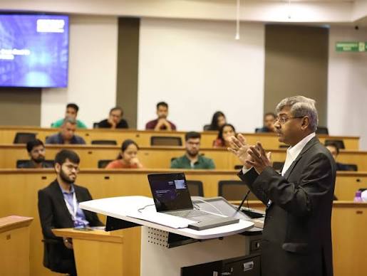 An experienced practitioner addressing a room of learners